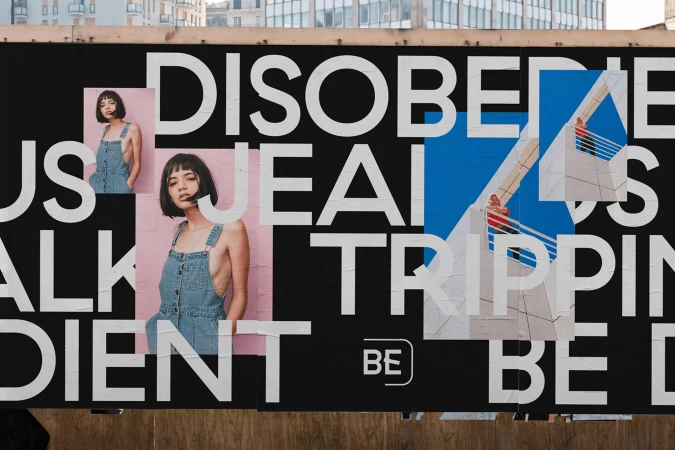 Outdoor billboard featuring photos of a young woman and an architectural building, alongside white and blue block lettering.