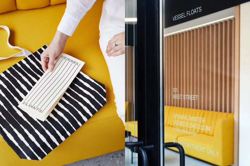 Person displaying a business card and tote bag on a yellow sofa, near a glass door with text leading to business interior.