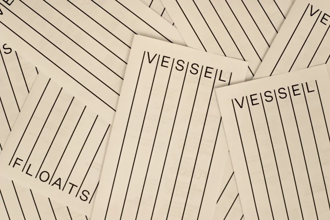 Scattered cream paper slips featuring black vertical line patterns and Vessel Floats typography branding.
