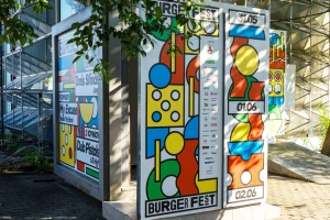 Colorful geometric graphic posters and festival branding panels mounted on an outdoor structure for Athens' Burger Fest.