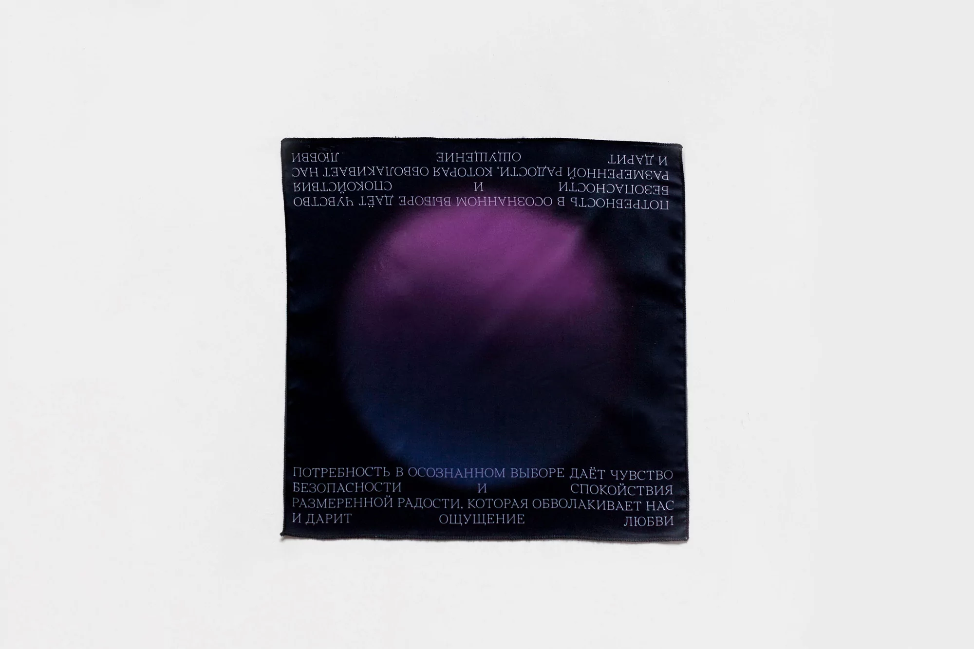Abstract art on fabric features a blend of purple and blue with surrounding Russian text, displayed against a bright white backdrop.