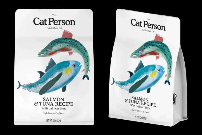 Two bags of Cat Person brand salmon & tuna recipe cat food, depicted with illustrations of a salmon and a tuna fish on a white background.