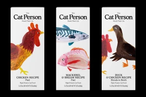 Three white cat food packaging cartons featuring illustrated animals including a rooster, fish, duck, and chicken.