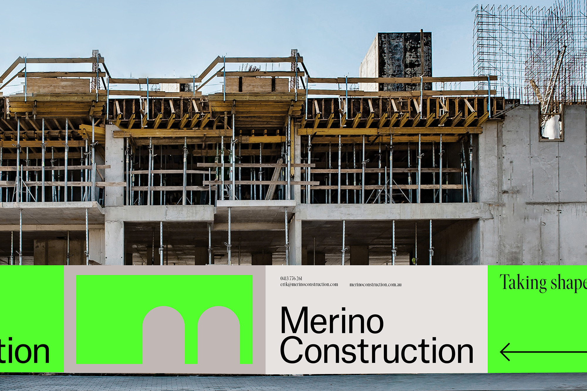 Unfinished concrete building under construction with scaffolding and steel supports against a blue sky with branding at the bottom.