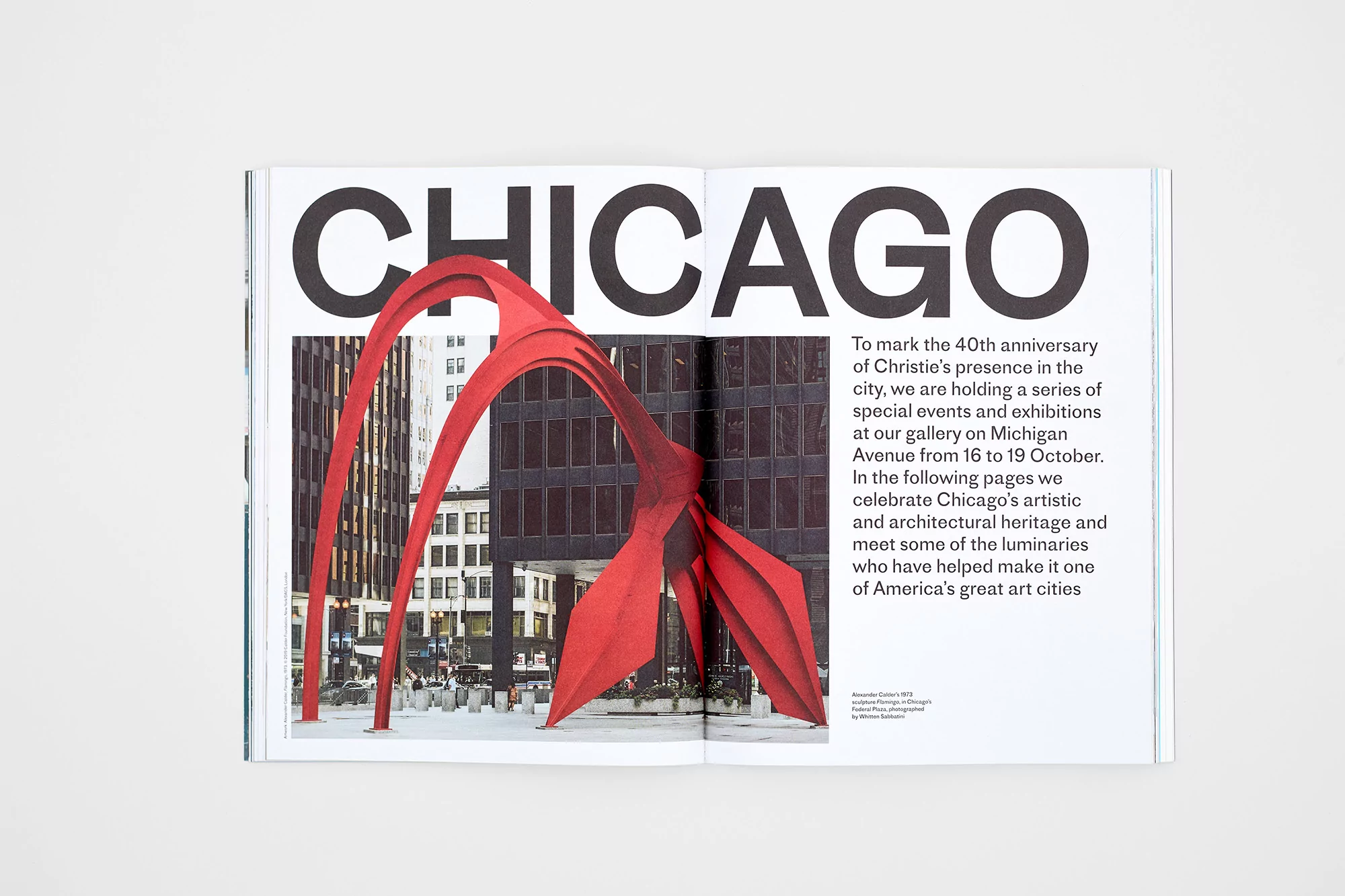 Magazine double-page spread featuring a red abstract sculpture against Chicago skyscrapers, bold typography, and descriptive text.