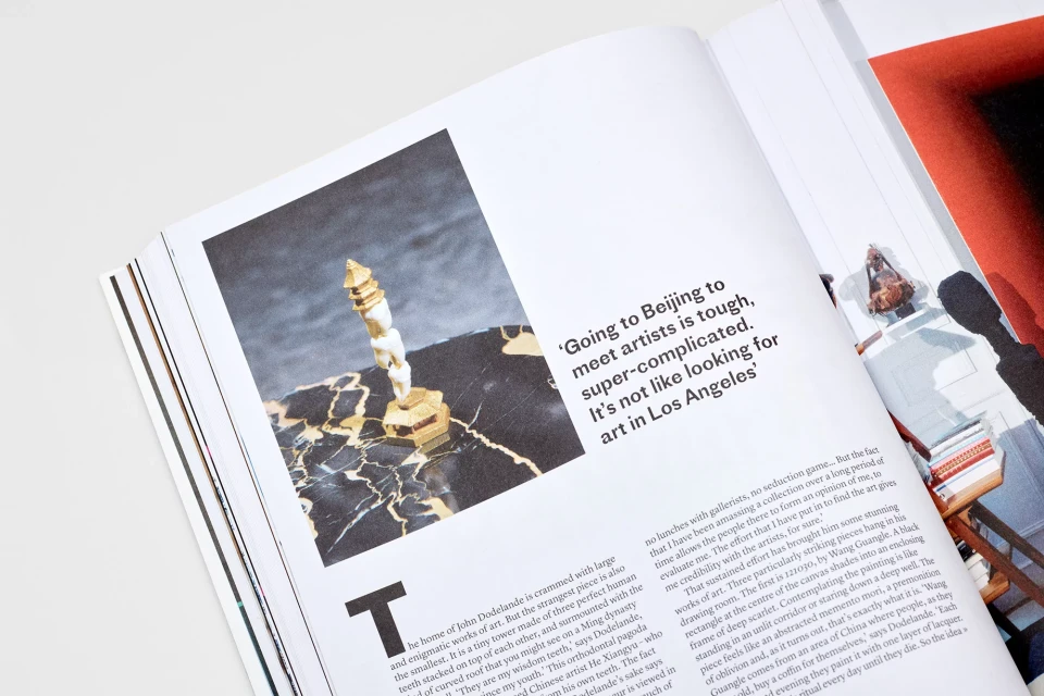 Magazine spread featuring an art piece made of teeth on a marble base next to article discussing Beijing's art scene.