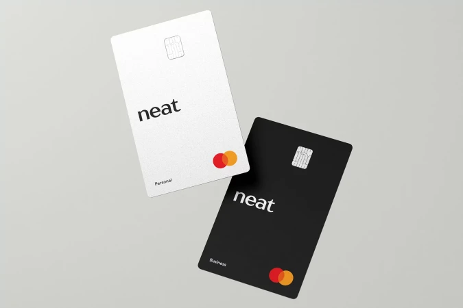 Two credit cards, one white labeled 'Personal' and one black labeled 'Business' with the word 'neat' in the center.