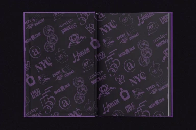 An open hardcover book displaying a dark purple patterned endpaper with various typographic symbols and brand icons.