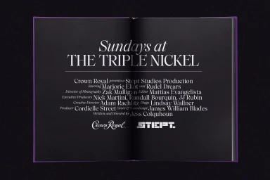 Open black book displaying elegant white typography credits and the Crown Royal logo against a dark background