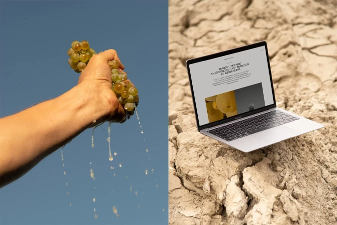 Close-up of a hand squeezing juice from grapes against blue sky, next to laptop on cracked earth. Wine or tech industry visuals.