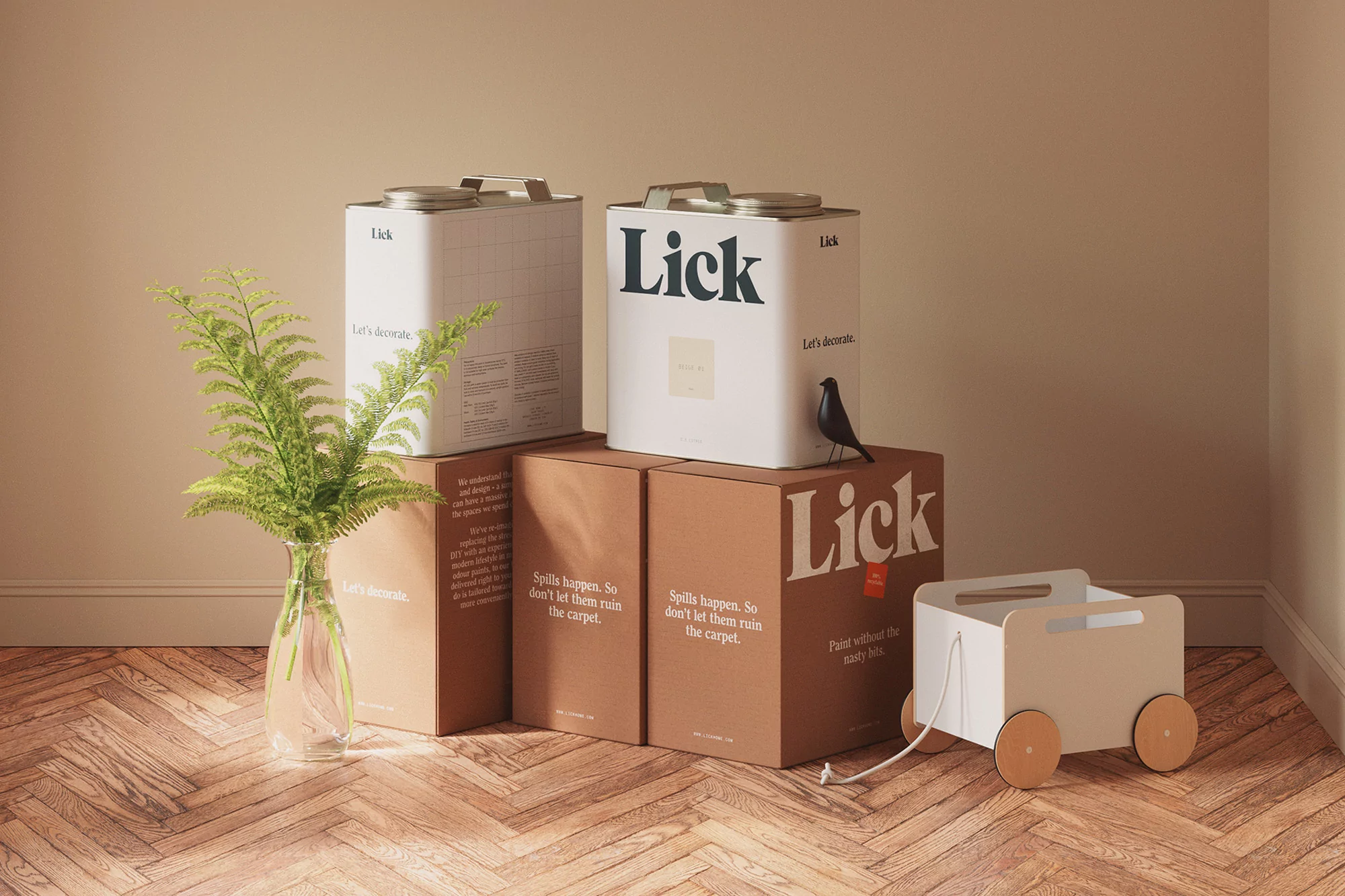 Two paint cans and cardboard boxes are arranged on a herringbone floor with a toy wagon and fern in a vase, product photography.