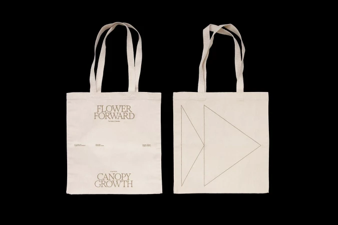 Two ecru canvas tote bags with geometric and text designs. Sustainable fashion, eco-friendly shopping, and promotional merchandise visuals.
