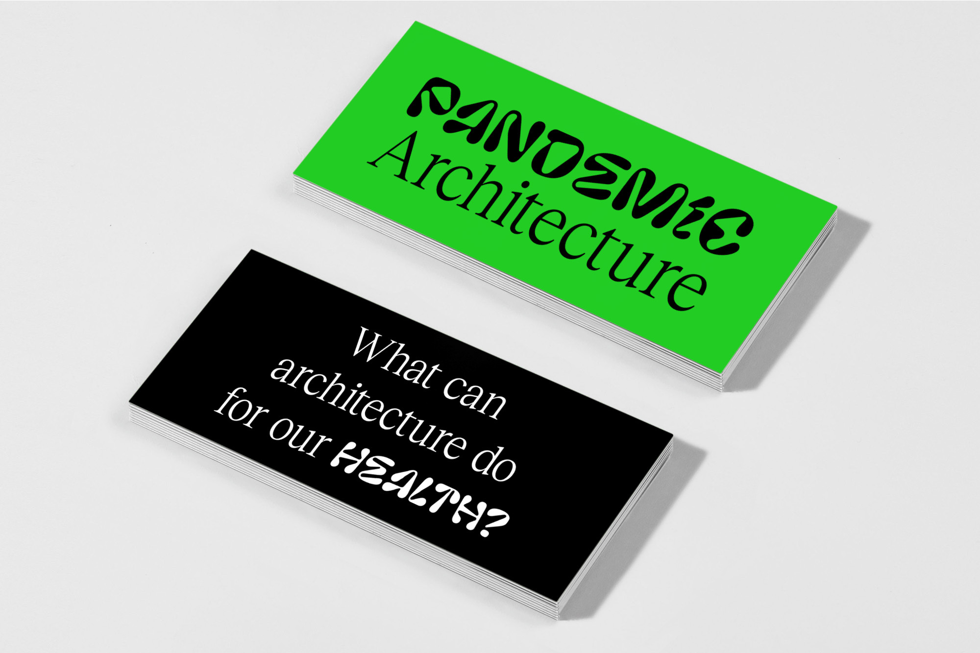 Two stacked sets of cards on a white surface, one green with the words 'Pandemic Architecture' and the other black with a question about architecture and health.