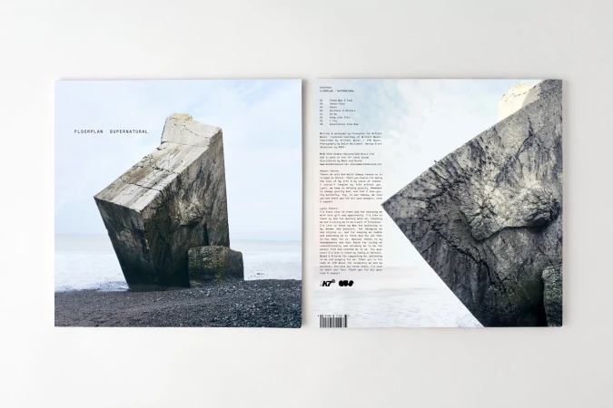 Album cover featuring a concrete block on a rocky beach under a light sky, alongside the tracklist and album information.