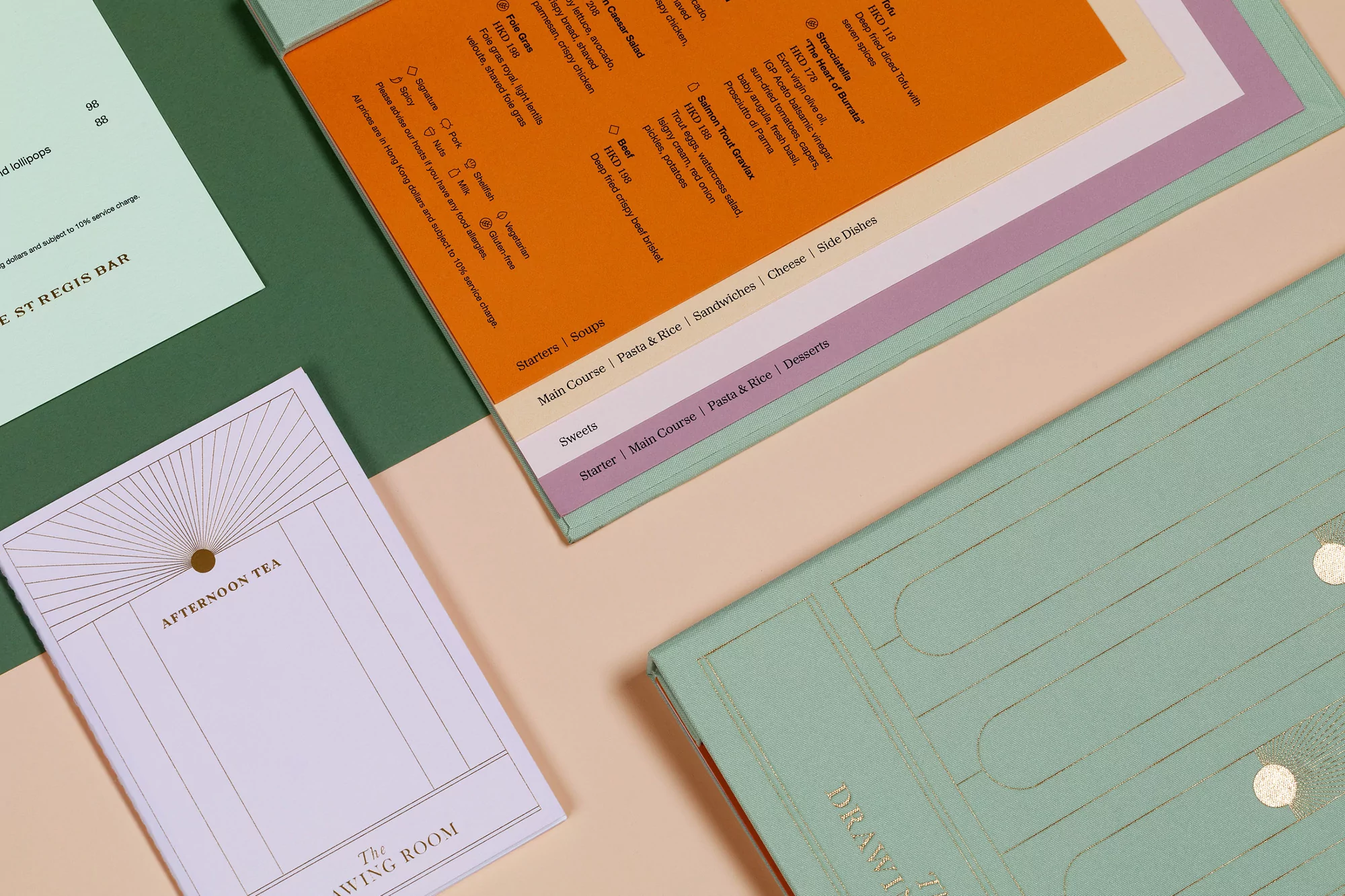 Close-up of menus and stationery for afternoon tea in The Drawing Room and St Regis Bar, featuring mint green and gold accents.