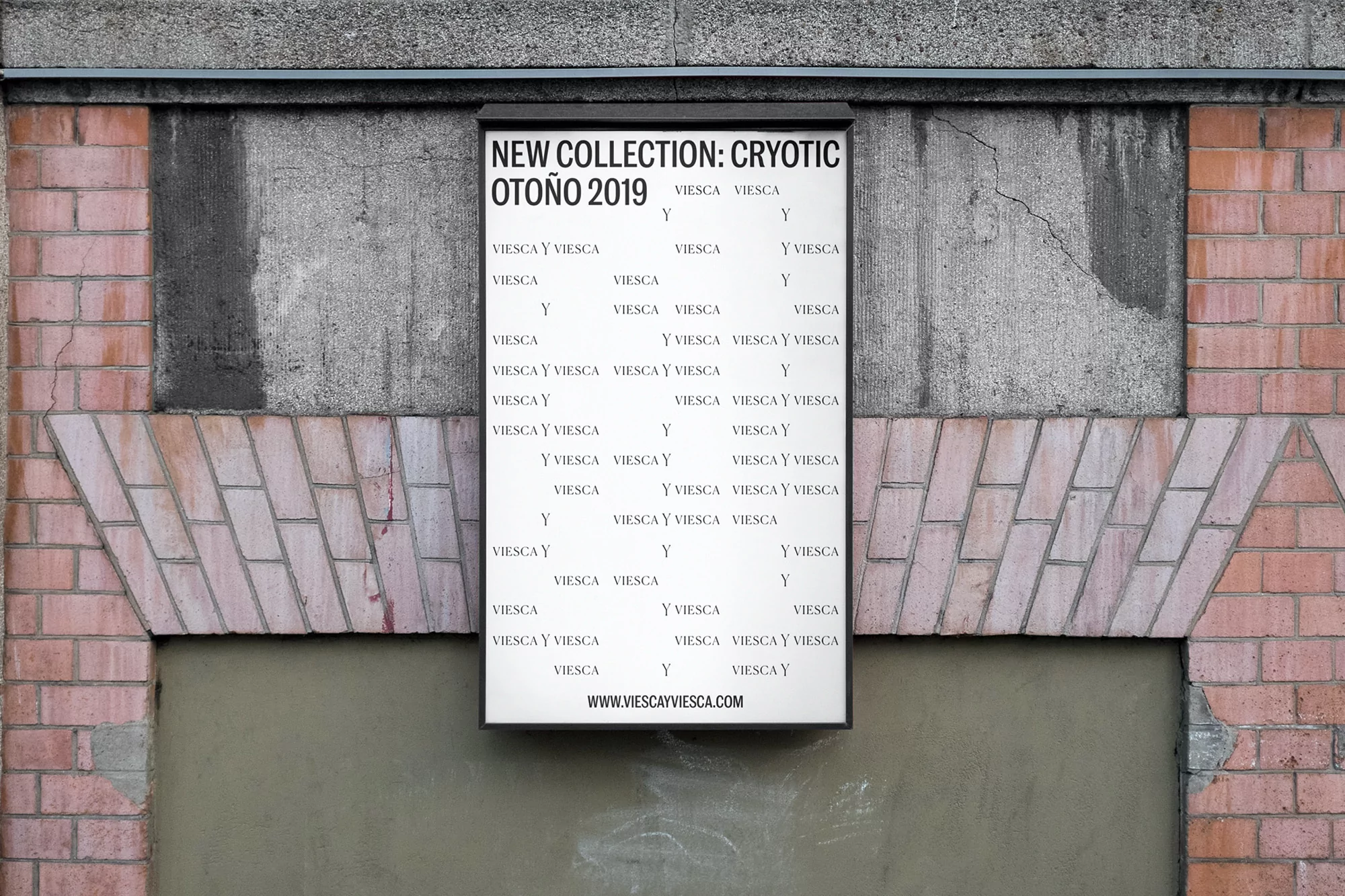 Poster on a brick wall for Viesca y Viesca new collection Otoño 2019 featuring brand names and URL against neutral gray wall.