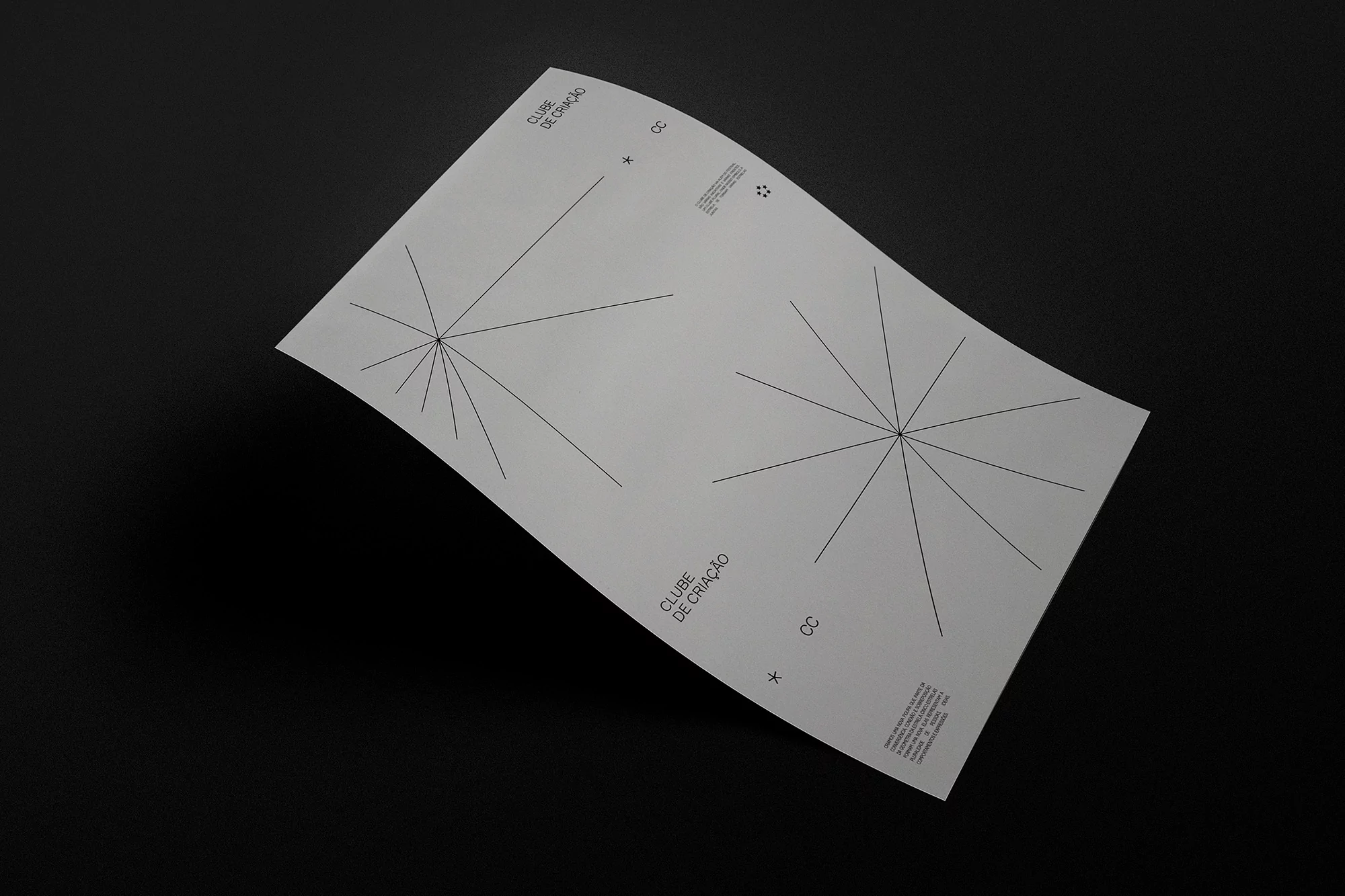 Promotional material featuring line art radiating from a central point on a sheet of white paper against a black background.