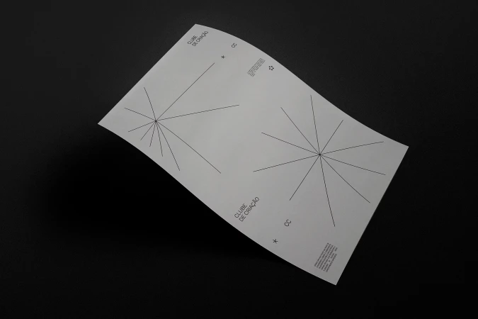 Promotional material featuring line art radiating from a central point on a sheet of white paper against a black background.