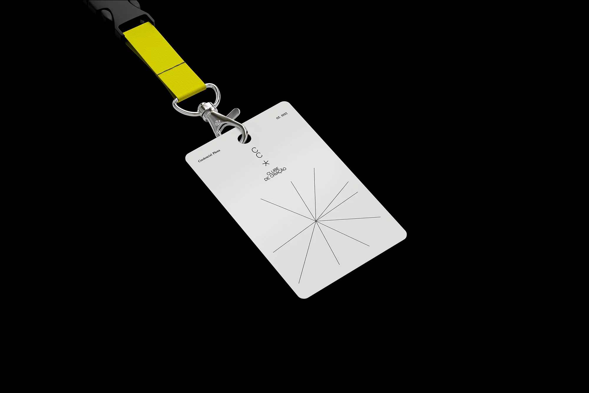 ID badge on a lanyard with a white card featuring a graphic of a star radiating from the center on a black background.