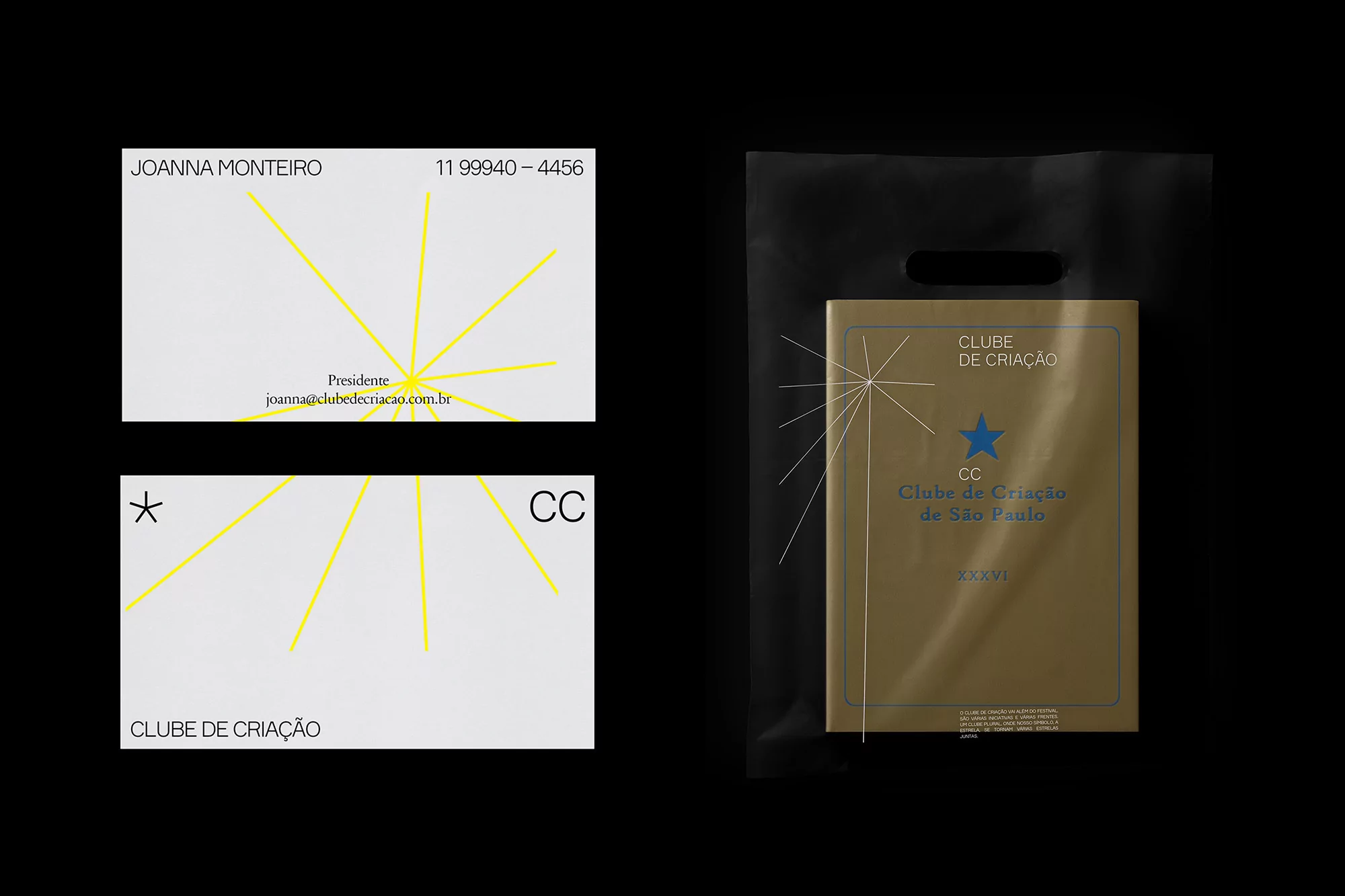 Stationery set featuring business cards and a gold book in a black bag on a black backdrop, showcasing the Clube de Criação design.