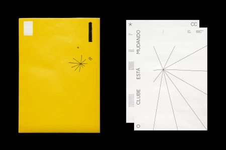 Vibrant yellow envelope and two white printed sheets with minimalist black typography and starburst line graphics against a black background