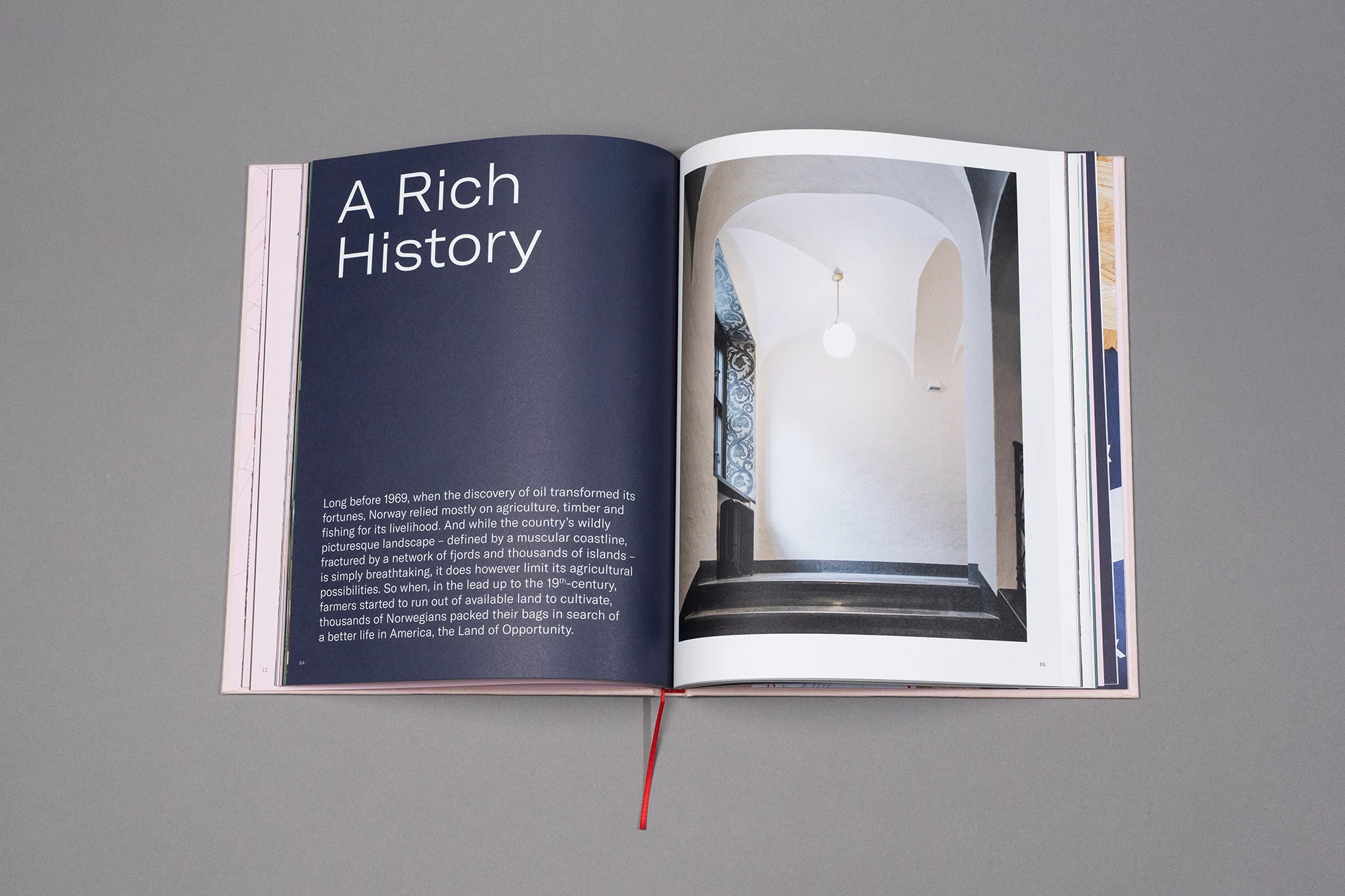 Open book with title 'A Rich History' next to a photograph of a brightly lit interior hallway with white arches and black stairs.