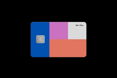 Credit card with a color-blocked geometric design in blue, pink, peach, and white featuring the text Ilior One against a black background