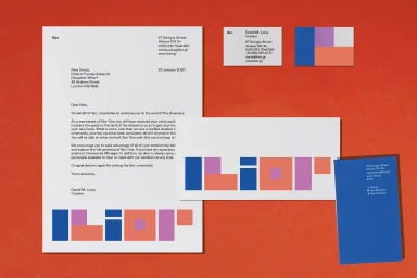 Ilior brand identity stationery featuring letterhead, business cards, and envelopes arranged on a textured orange surface