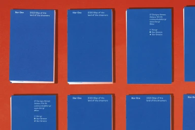 Multiple blue rectangular brochures with white typography arranged neatly on a solid orange background.