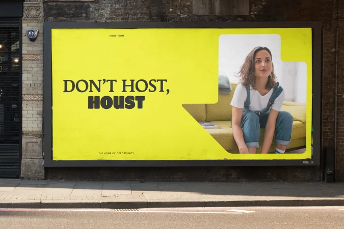 Outdoor advertising billboard featuring the word 'HOUST' in bold font. An image inset shows a woman on a couch indoors.