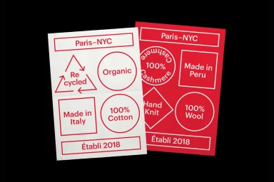 Two rectangular brand identity cards featuring red typography and geometric symbols on white and red backgrounds against a black surface.