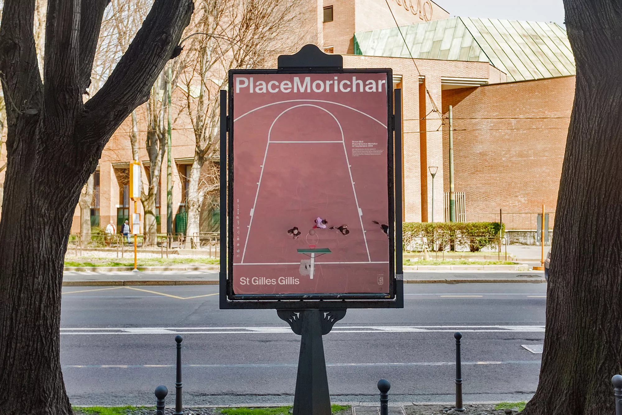 Outdoor shot of Place Morichar basketball court graphic displayed on a signpost, surrounded by trees and an urban street.