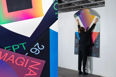 A person placing a large colourful geometric poster on a white wall for the MAPP MTL brand identity project.