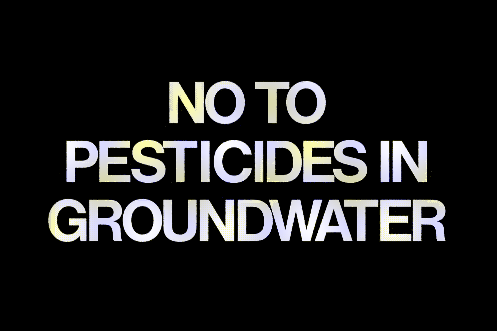 A stark black background features the bold white text 'NO TO PESTICIDES IN GROUNDWATER' in a straightforward, attention-grabbing layout.