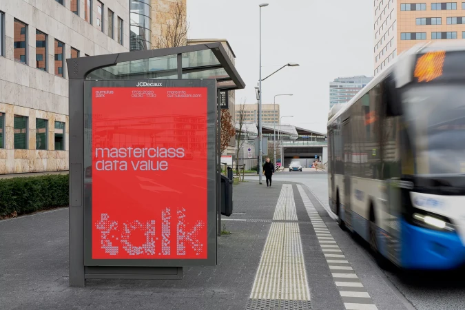 Red advertising poster displaying masterclass data value text inside a bus stop shelter on a city street.