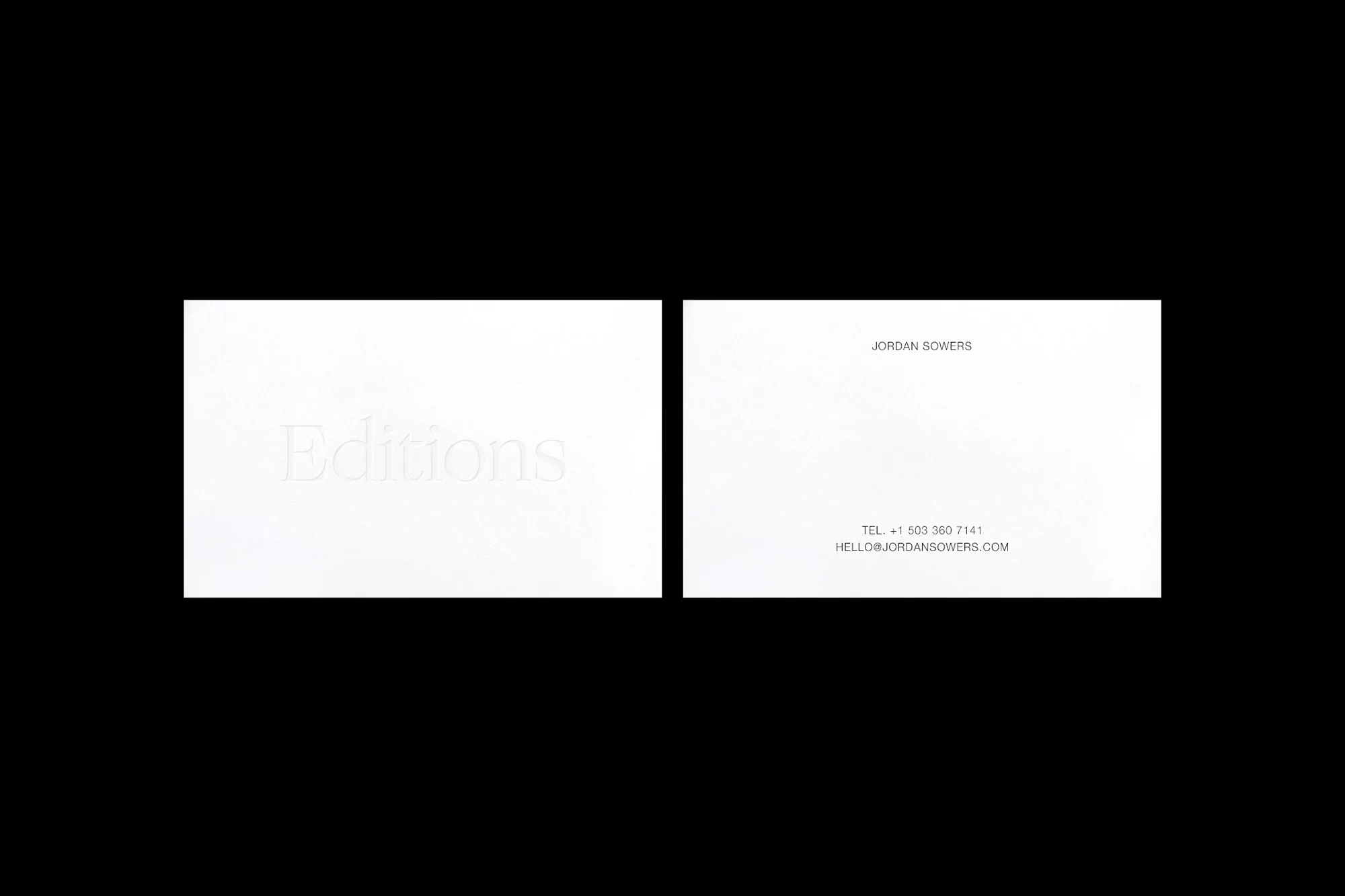 Two white business cards with subtle embossed text on a black background, featuring company name 'Editions' and contact details.