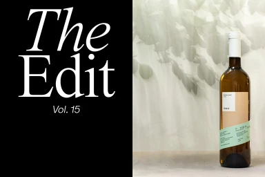 Verkat wine bottle on a pale surface with leaf shadows, next to a black panel with white typography reading The Edit Vol. 15