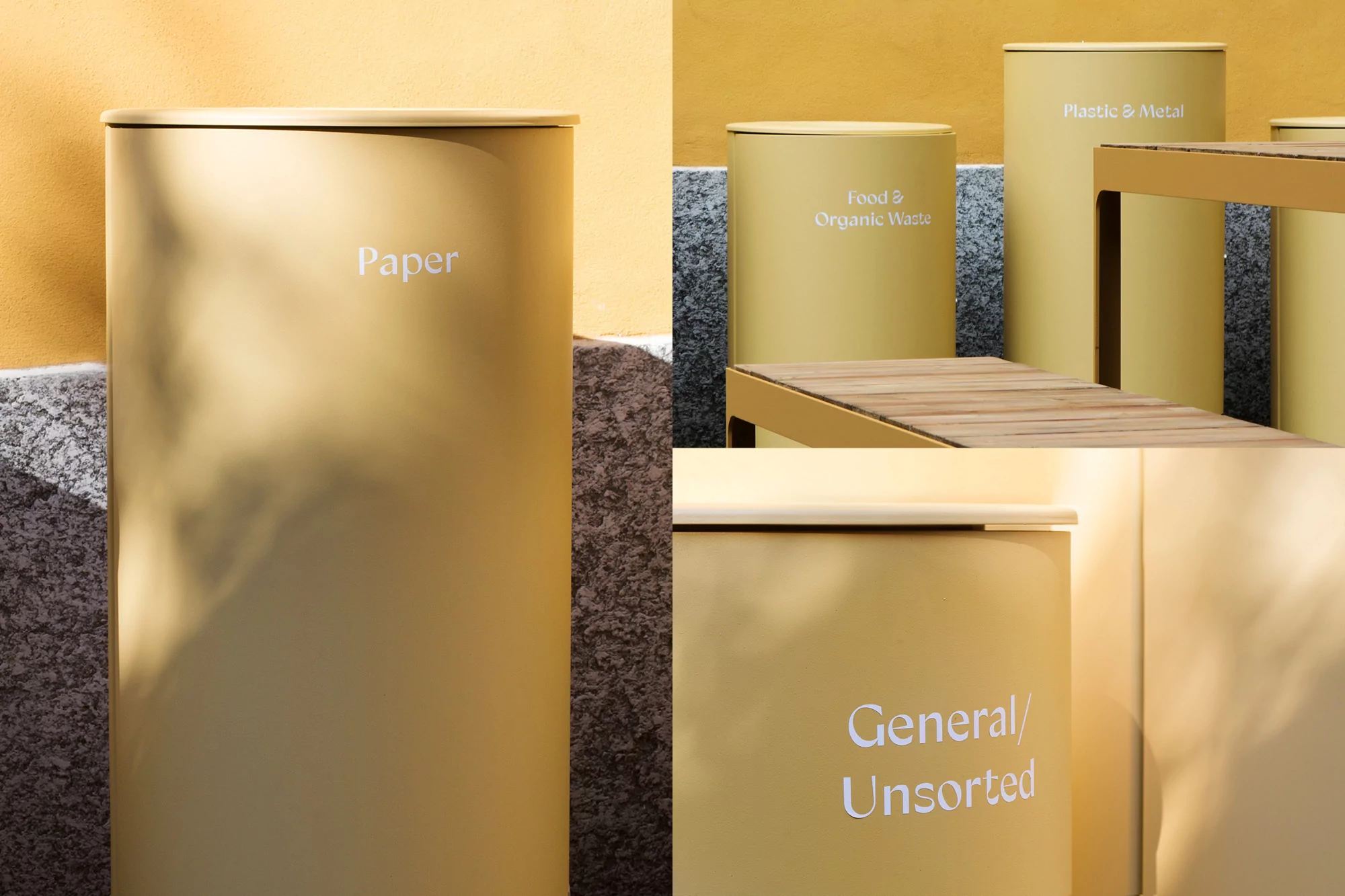 Beige metal recycling bins for paper, plastic, metal, food and general waste stand on a stone base against a yellow wall outdoors.
