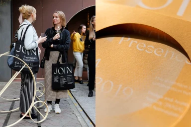 Two women holding black tote bags with white JOIN branding standing outdoors near a textured golden paper design detail