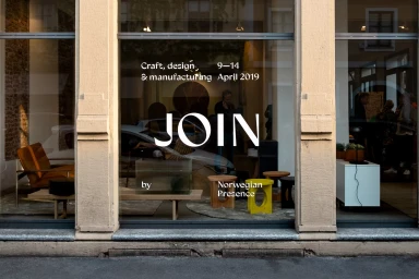 Storefront window with large white JOIN typography and exhibition details displayed on glass