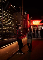 Man and woman talking on a lit rooftop at night near a glowing neon BURGER SHACK sign for A Twist At Every Turn by Visit Victoria