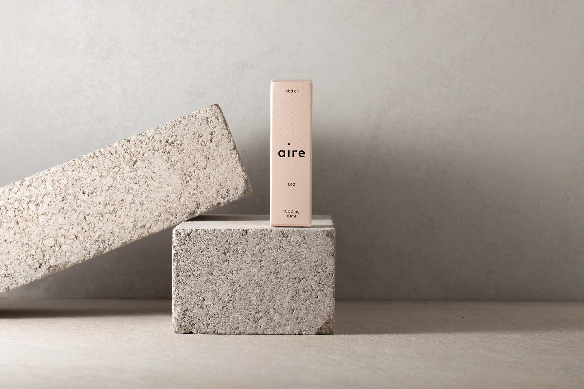CBD oil product package on concrete blocks, minimalist studio product shot for beauty and healthcare industry. Close-up product focus.