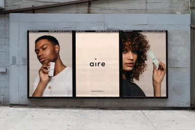 Three outdoor advertising billboards featuring brand identity for Aire mounted on a weathered grey concrete wall