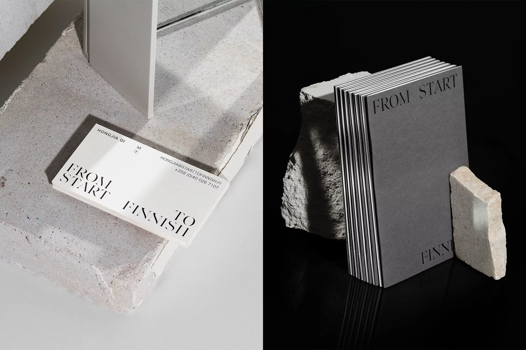 Close-up studio shot of business cards with minimalist black text on a white and gray stone background, creating a clean, professional design.