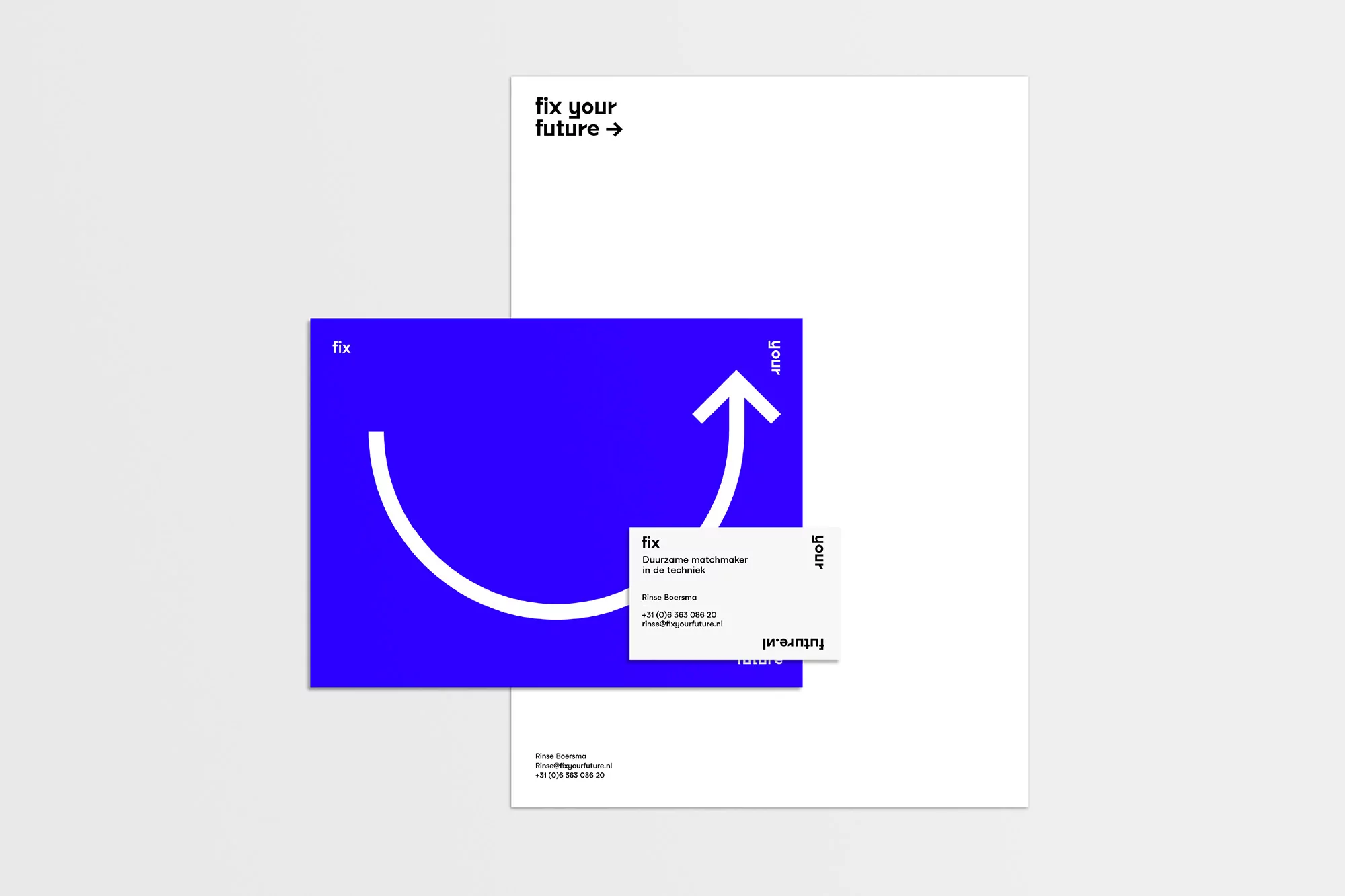Letterhead and business card featuring a blue square with a white curved arrow graphic, next to a white sheet with text, on a white surface.