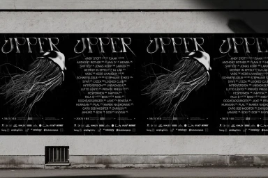 Four black event posters featuring jellyfish illustrations and white typography pasted on a textured concrete wall.