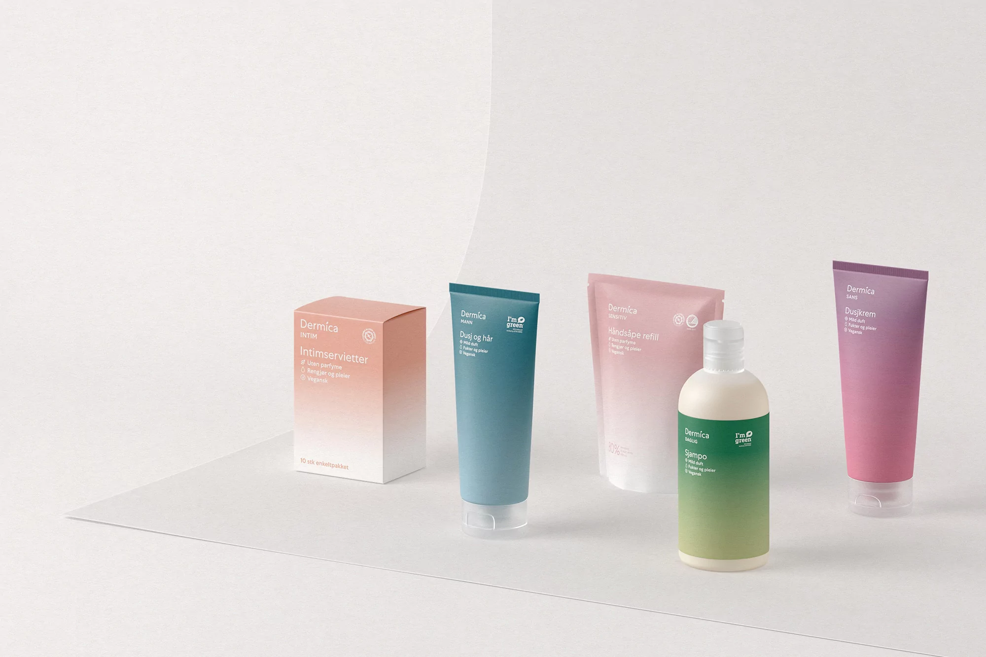Studio shot of Dermica skincare products in pink, blue, green, and purple gradient packaging against a clean, minimalist background.