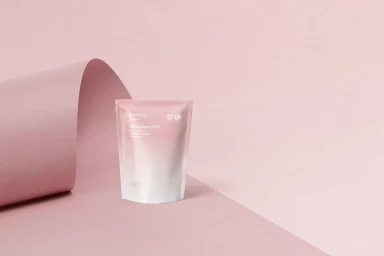 Pink and white refill pouch on a curved pale pink studio backdrop for Apotek1 brand identity