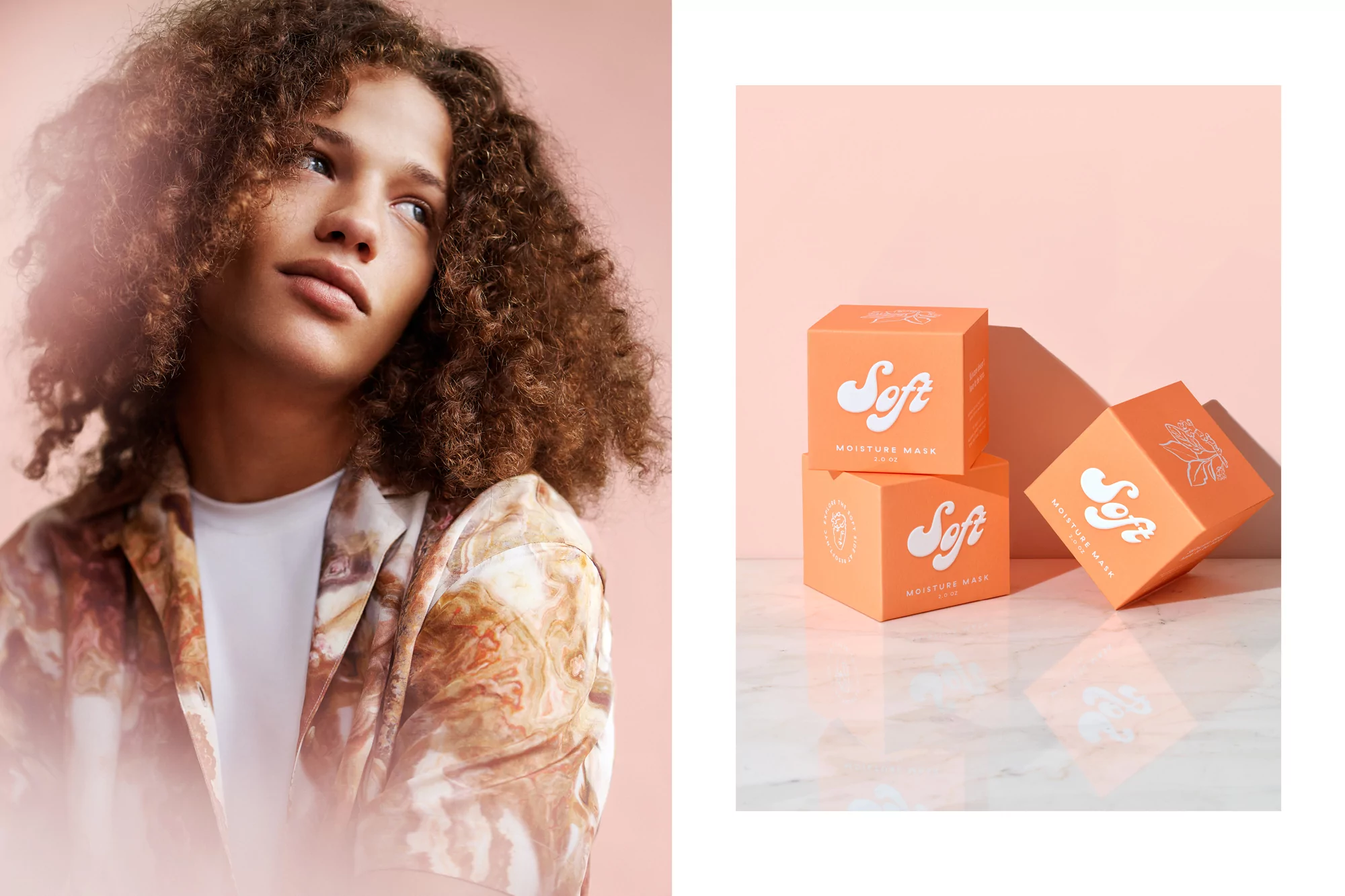 A young adult with curly hair gazes left, standing next to stacked peach-colored skincare boxes on a light marble surface.