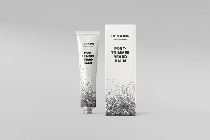 Remains facial hair care products featuring a tube of post-trimmer beard balm and its cardboard container, both with minimalist designs.